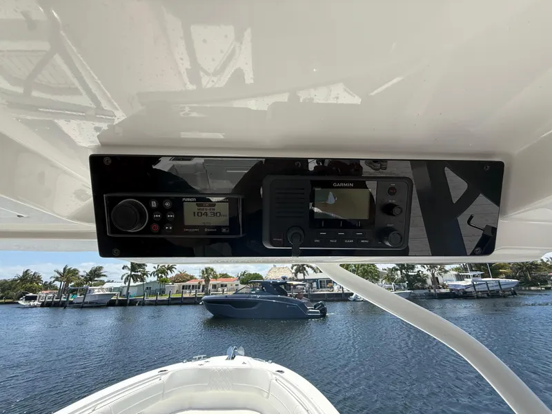 Slide: The Image of 2022 Edgewater 262 CX boat dashboard with navigation equipment, overlooking a serene waterfront. - 28