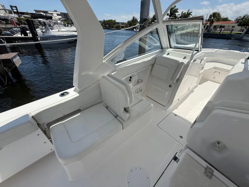 Slide: The Image of 2022 Edgewater 262 CX boat interior with white seating and waterfront view. - 29