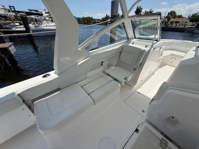 Slide: The Image of 2022 Edgewater 262 CX boat interior with white seating, docked by the water. - 31