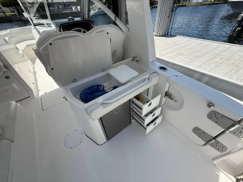 Slide: The Image of 2022 Edgewater 262 CX boat interior with storage compartments and water view. - 44