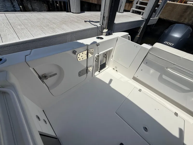 Slide: The Image of 2022 Edgewater 262 CX boat interior, featuring a clean, spacious deck near a dock. - 45