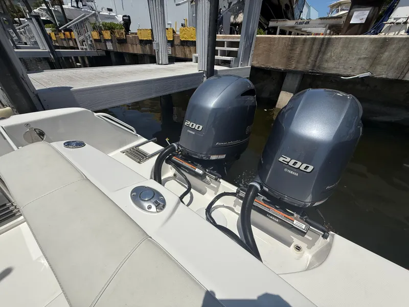 Slide: The Image of 2022 Edgewater 262 CX boat with twin 200 horsepower engines docked at marina. - 46