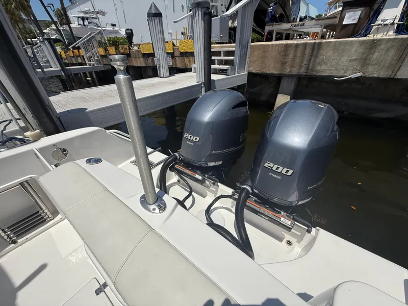 Slide: The Image of 2022 Edgewater 262 CX boat with twin 200 horsepower engines docked at marina. - 47