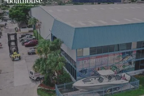 Slide: The Image of 2022 Edgewater 262CX Crossover boat displayed outside a large blue-roofed building. - 61
