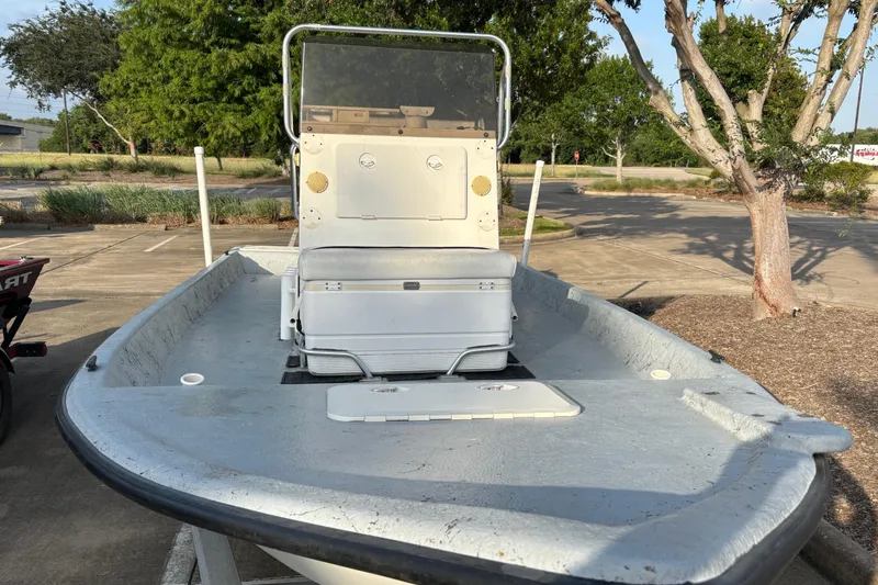 Slide: The Image of A 2001 Destiny boat with console and seating, parked outdoors on a sunny day. - 3