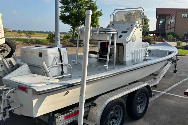 Slide: The Image of White Destiny boat on trailer, 2001 model, parked outdoors near a building. - 7