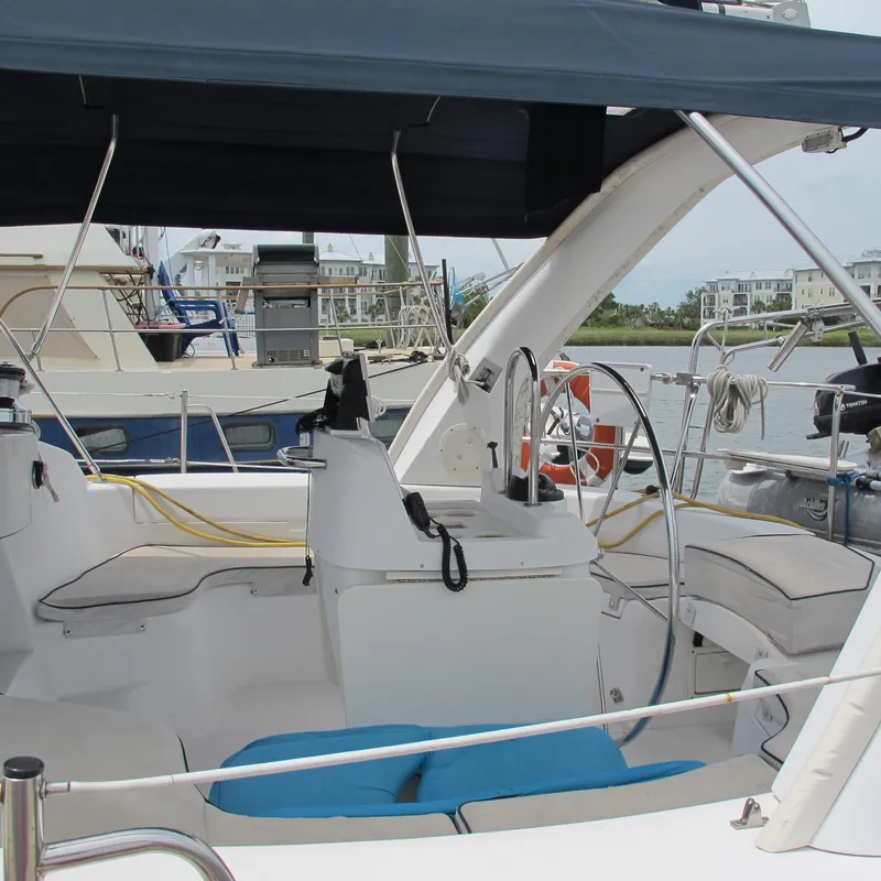 Slide: The Image of 1998 Hunter 410 sailboat cockpit with seating, steering wheel, and marina view. - 18
