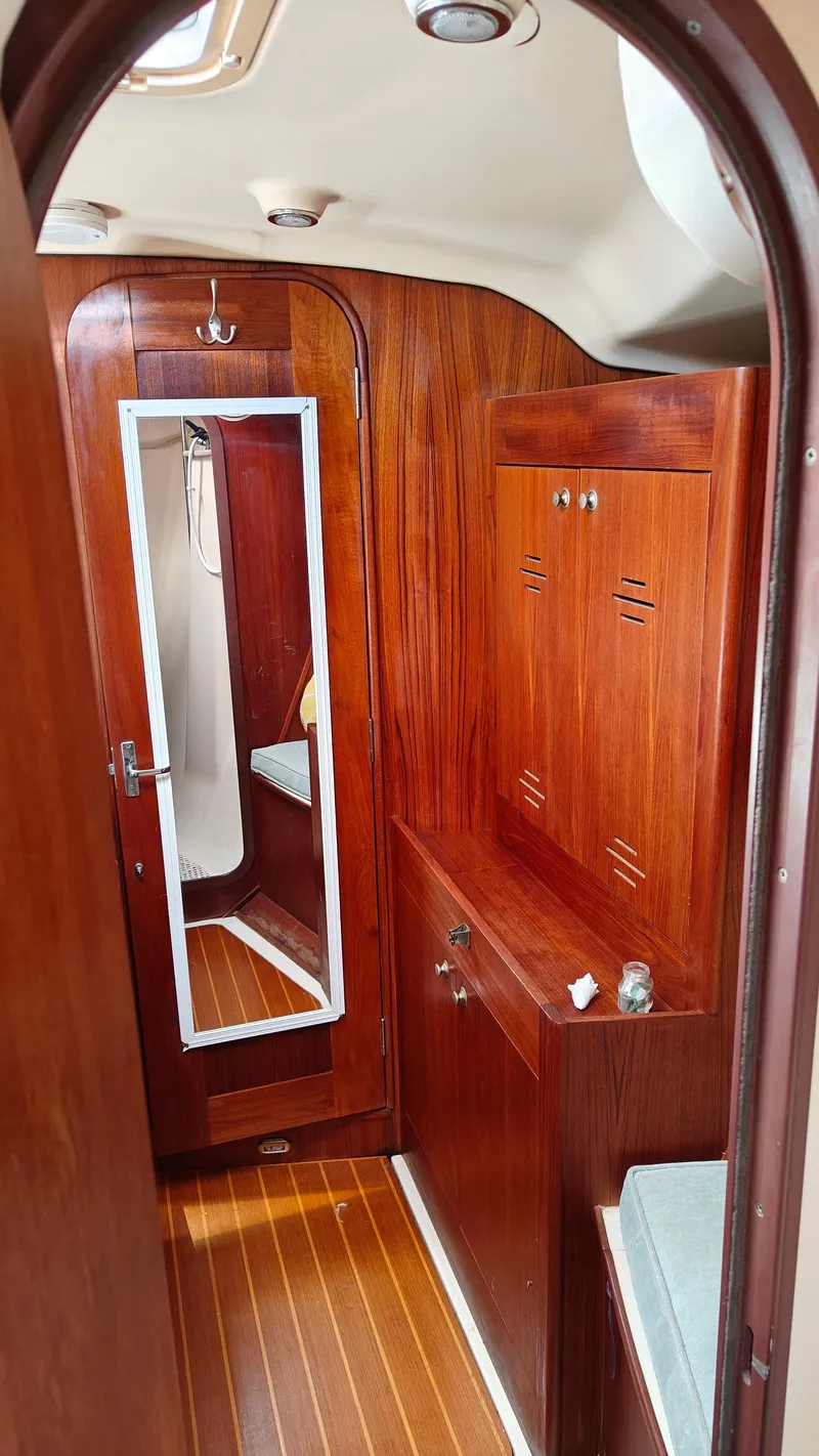 Slide: The Image of Interior of a 1998 Hunter 410 sailboat with wooden cabinetry and mirror. - 22