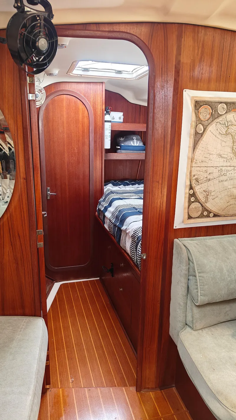 Slide: The Image of Interior of a 1998 Hunter 410 sailboat with wood paneling and cozy sleeping area. - 25
