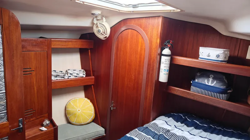 Slide: The Image of Cozy cabin interior of 1998 Hunter 410 sailboat with wooden finish and nautical decor. - 27