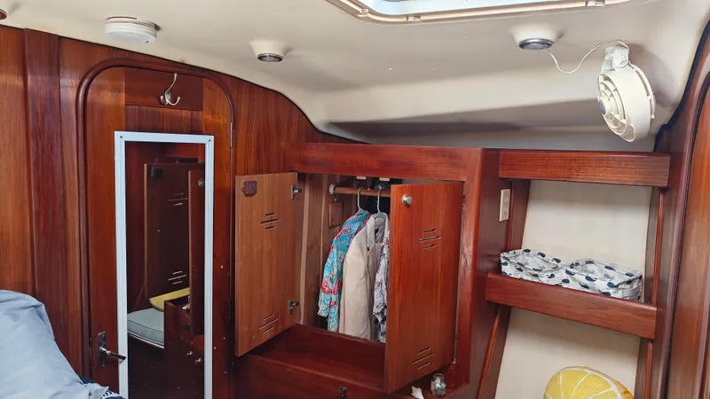 Slide: The Image of Interior of a 1998 Hunter 410 sailboat with wooden cabinetry and storage. - 29