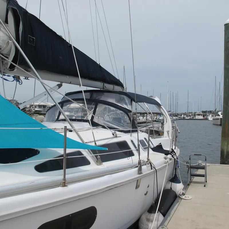 Slide: The Image of 1998 Hunter 410 sailboat docked at marina, featuring sleek design and spacious deck. - 3