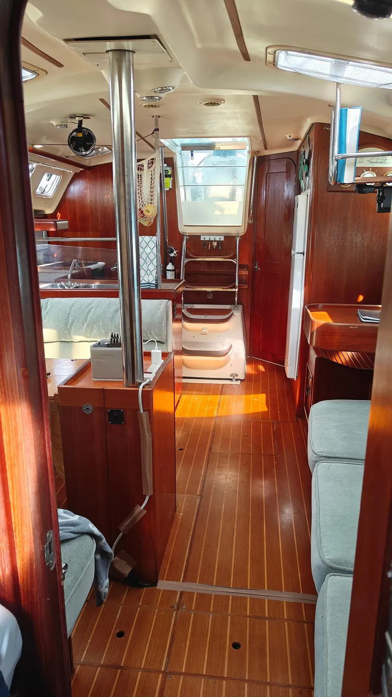 Slide: The Image of Interior of a 1998 Hunter 410 sailboat with wooden flooring and cozy seating. - 31