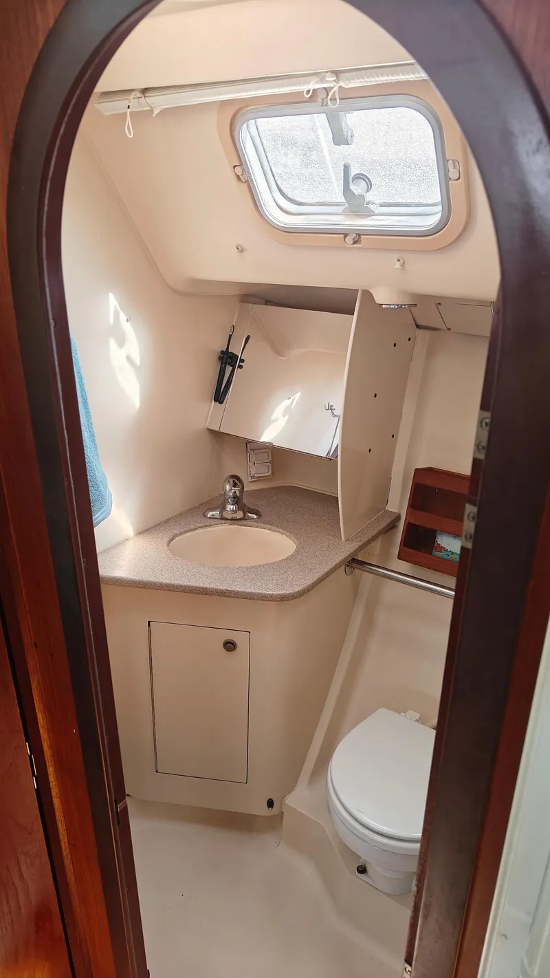 Slide: The Image of 1998 Hunter 410 yacht bathroom with sink, toilet, and window. - 38
