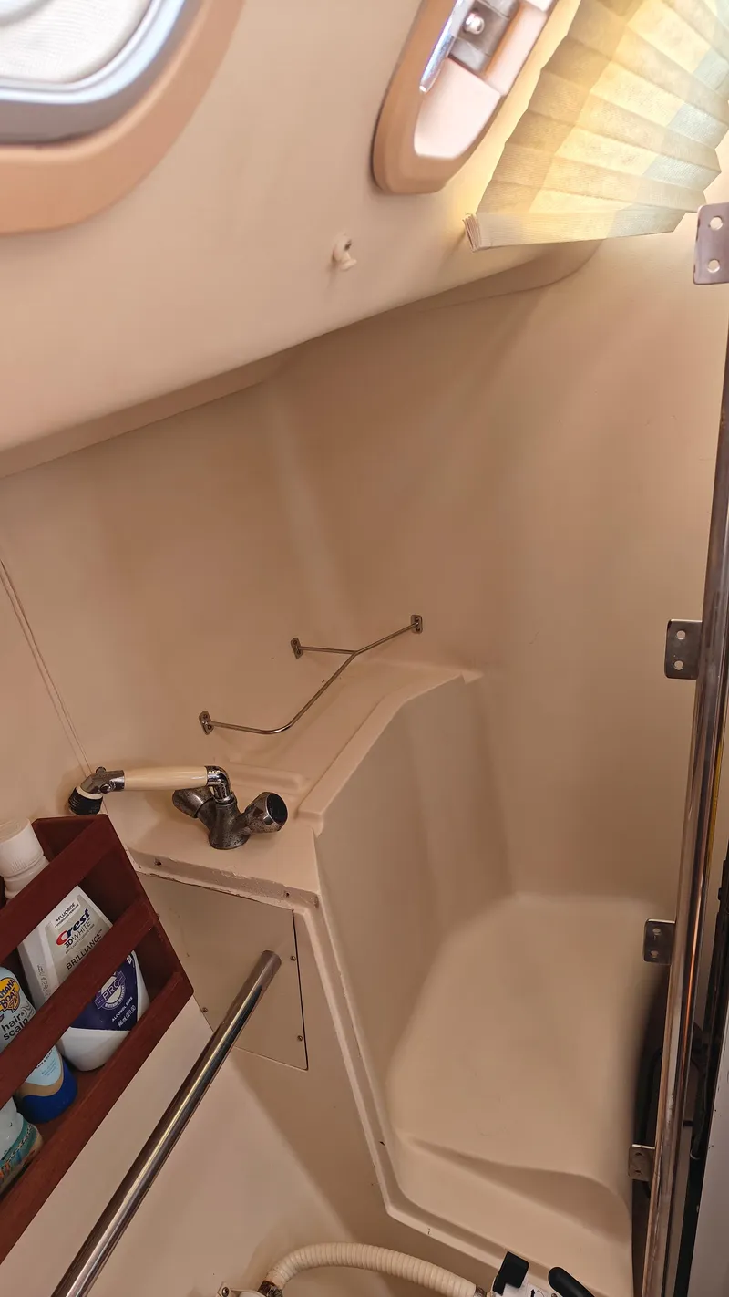 Slide: The Image of 1998 Hunter 410 boat bathroom with shower, sink, and storage shelves. - 39