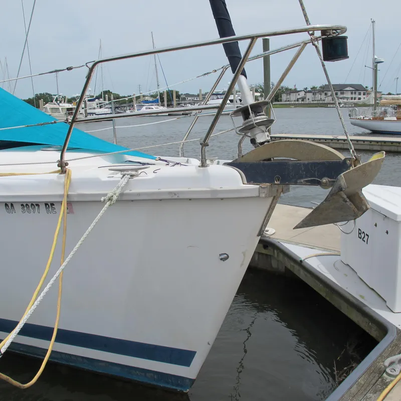 Slide: The Image of 1998 Hunter 410 sailboat docked at marina with blue cover and anchor. - 4