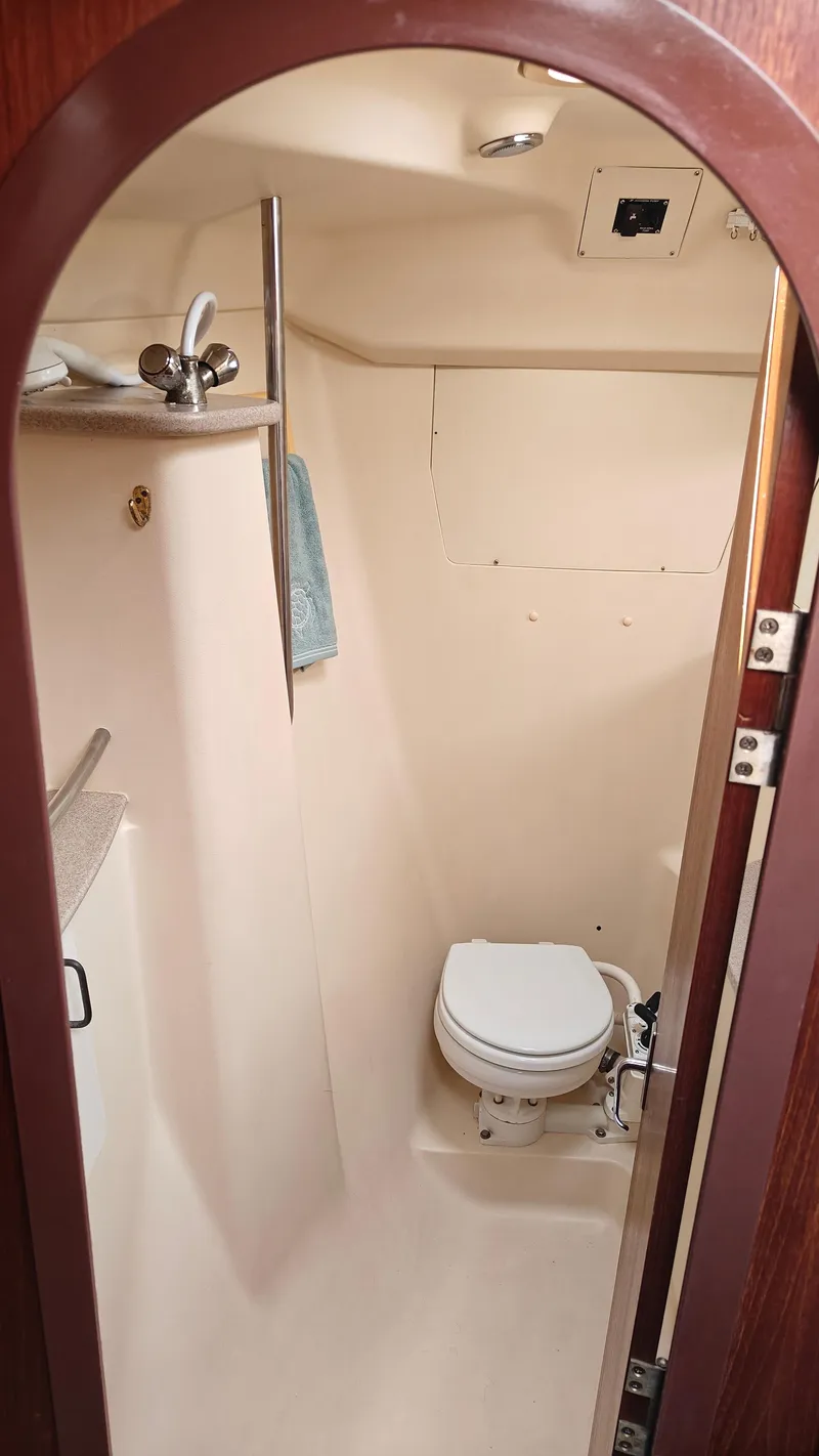 Slide: The Image of 1998 Hunter 410 boat bathroom with compact toilet and sink. - 40