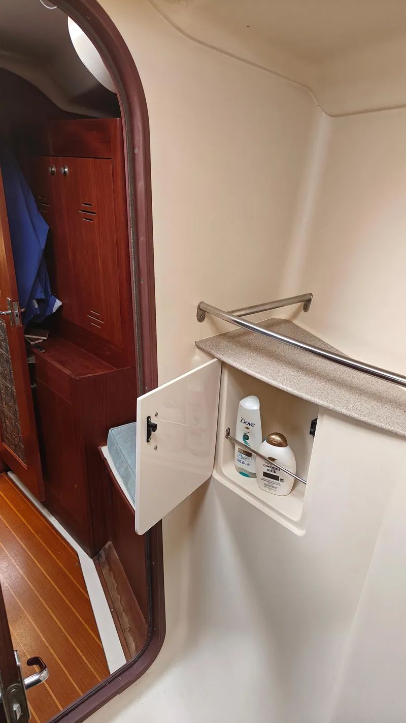 Slide: The Image of 1998 Hunter 410 yacht interior with open cabinet and toiletries. - 46