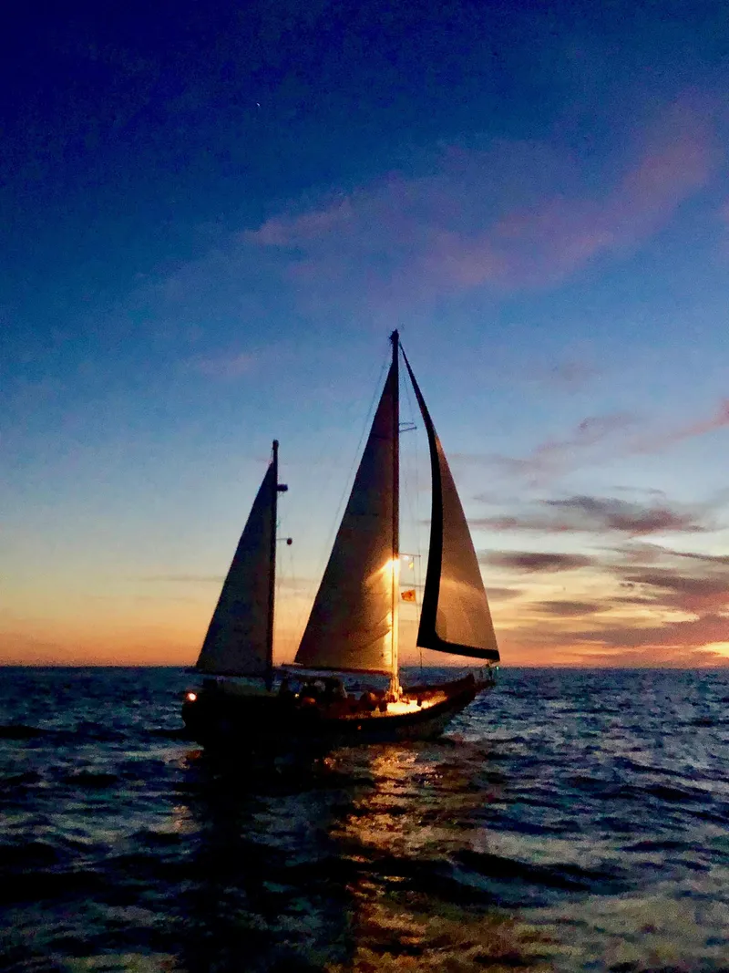 Slide: The Image of Sailing yacht Formosa 51 at sunset, 1975 model, silhouetted against a vibrant sky. - 2