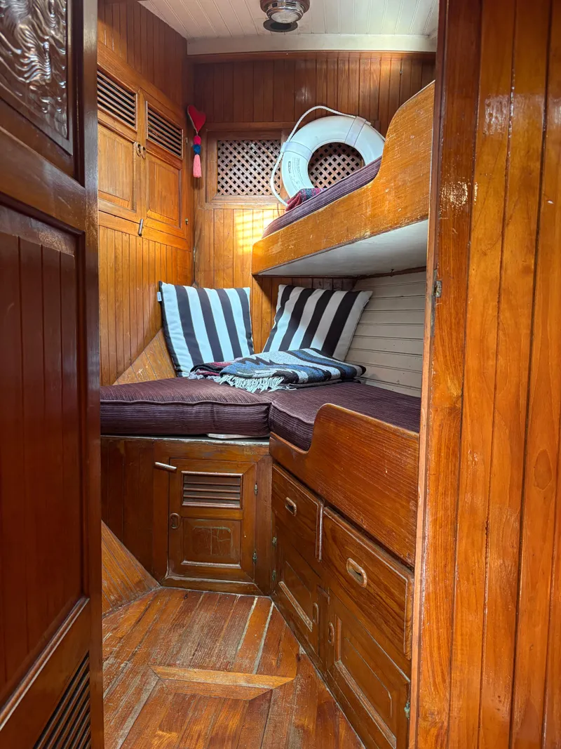Slide: The Image of 1975 Formosa 51 yacht interior with wooden paneling and cozy bunk beds. - 20
