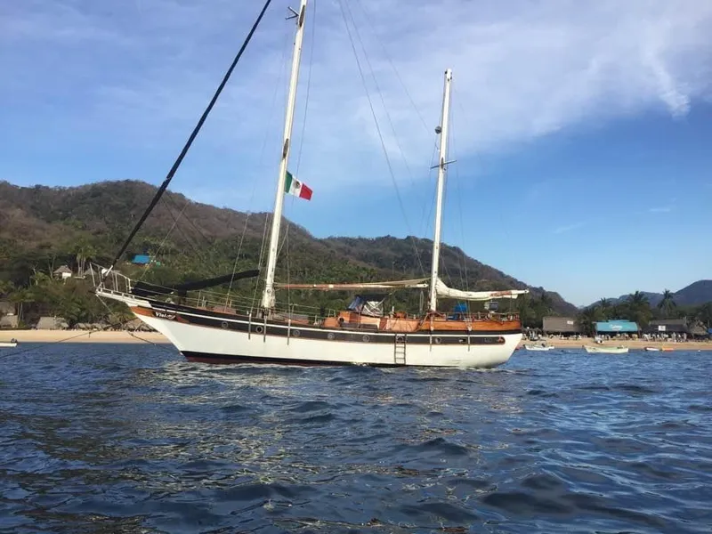 Slide: The Image of Sailing yacht Formosa 51, 1975 model, anchored near a scenic coastline. - 24