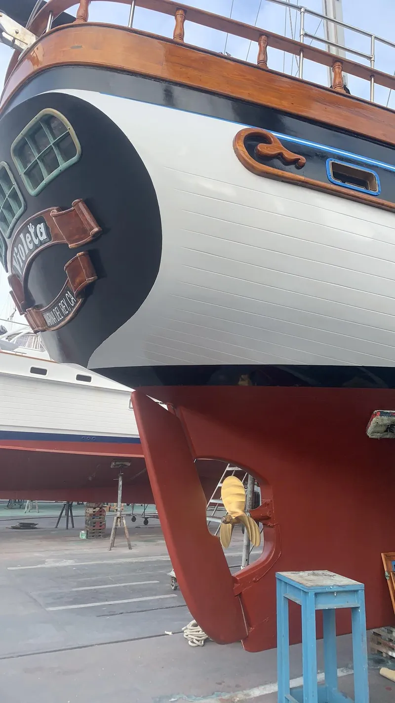 Slide: The Image of 1975 Formosa FORMOSA 51 sailboat, detailed stern and rudder view, docked for maintenance. - 25