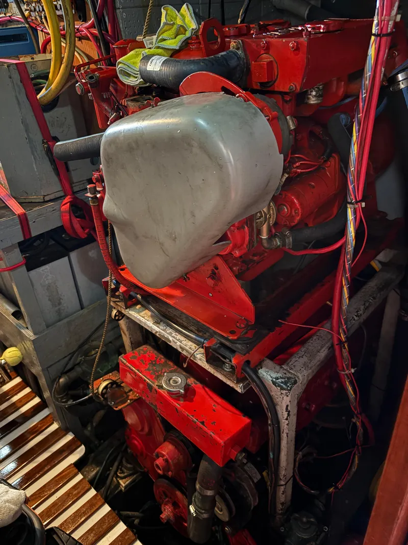 Slide: The Image of Engine room of a 1975 Formosa 51 sailboat with visible red engine components. - 27