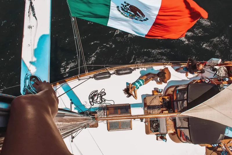 Slide: The Image of Aerial view of 1975 Formosa 51 sailboat with Mexican flag, people relaxing on deck. - 3