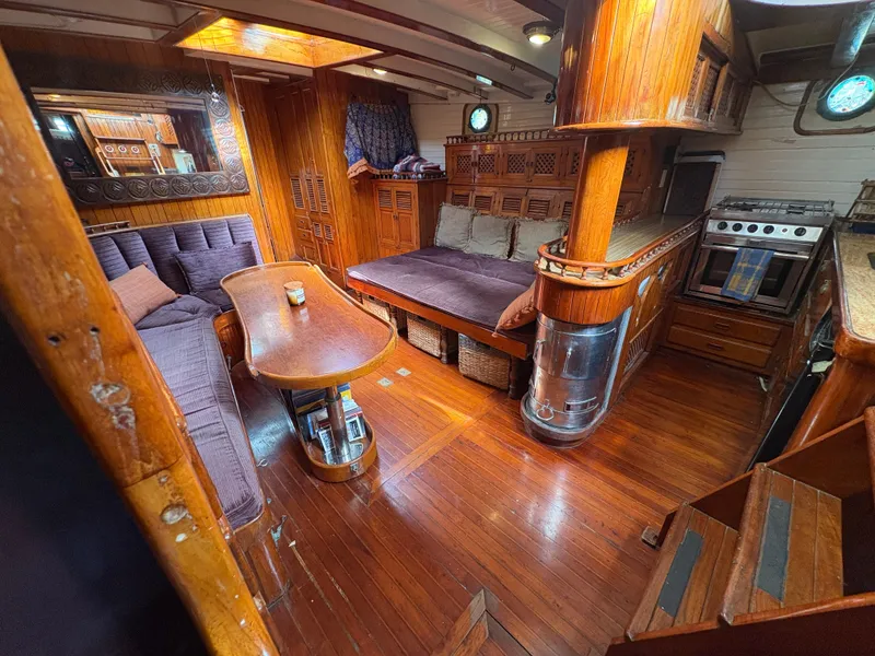 Slide: The Image of Luxurious 1975 Formosa 51 yacht interior with wooden furnishings and cozy seating area. - 5