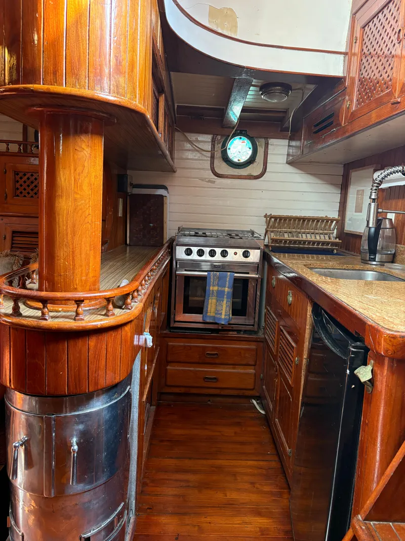 Slide: The Image of 1975 Formosa 51 yacht kitchen with wood finish, stove, and porthole window. - 6