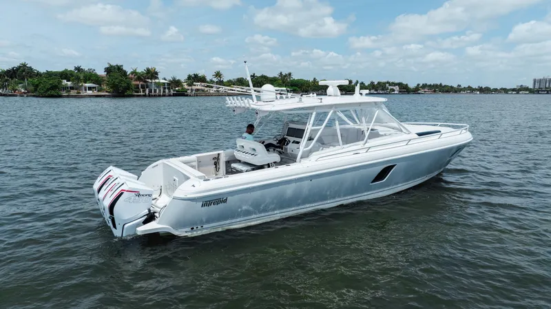 Slide: The Image of 2013 Intrepid 400 Cuddy boat on calm water under a partly cloudy sky. - 2
