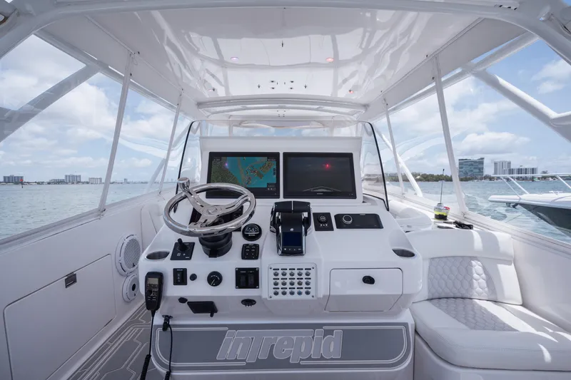 Slide: The Image of 2013 Intrepid 400 Cuddy helm with navigation screens and steering wheel, on open water. - 32