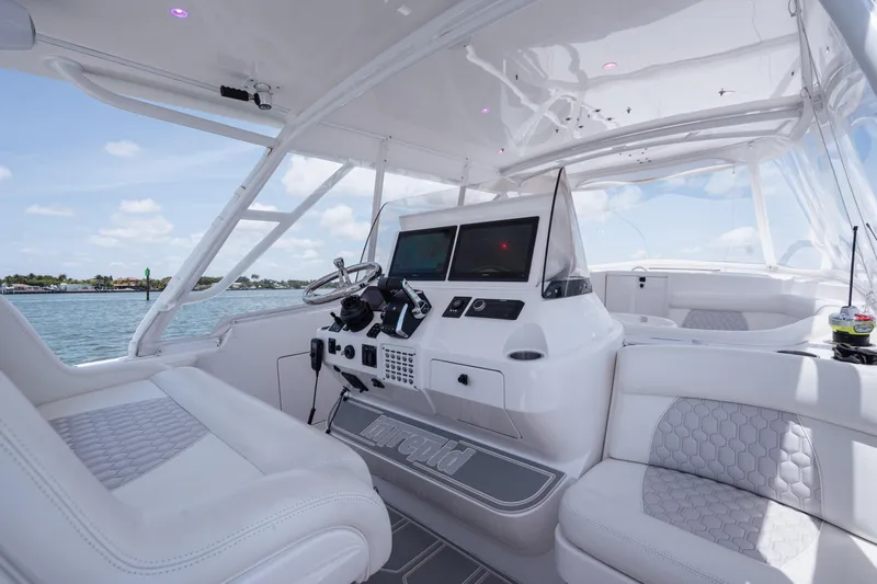 Slide: The Image of 2013 Intrepid 400 Cuddy boat interior with modern helm and seating, on a sunny day. - 36