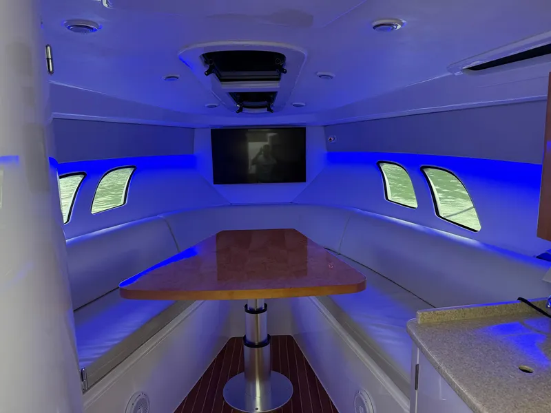 Slide: The Image of Interior of 2013 Intrepid 400 Cuddy with blue lighting and a wooden table. - 45