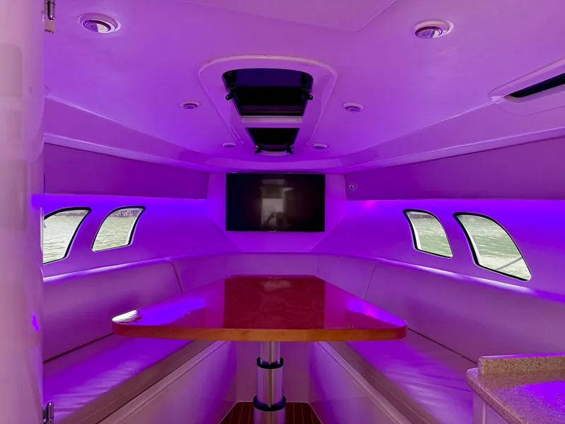 Slide: The Image of 2013 Intrepid 400 Cuddy interior with purple lighting and a central table. - 47