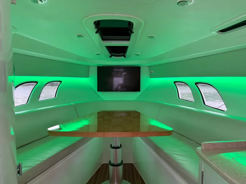Slide: The Image of 2013 Intrepid 400 Cuddy interior with green LED lighting and modern seating area. - 49