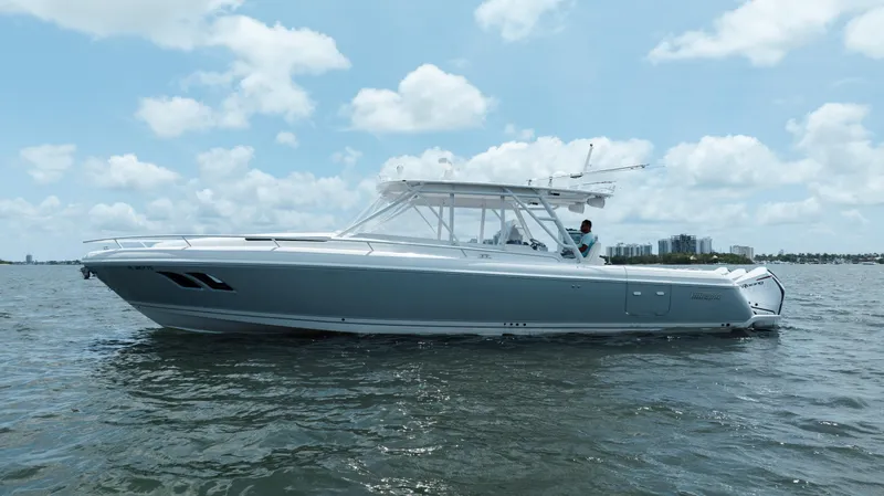 Slide: The Image of 2013 Intrepid 400 Cuddy boat on calm water under a partly cloudy sky. - 6