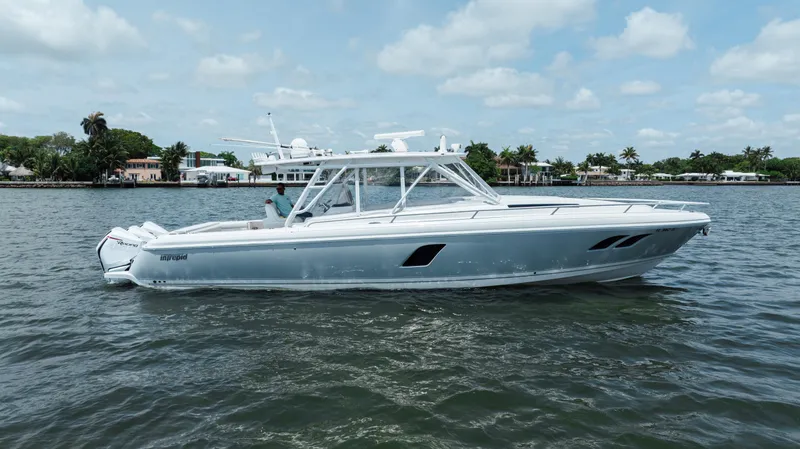 Slide: The Image of 2013 Intrepid 400 Cuddy boat on calm water, under a partly cloudy sky. - 8