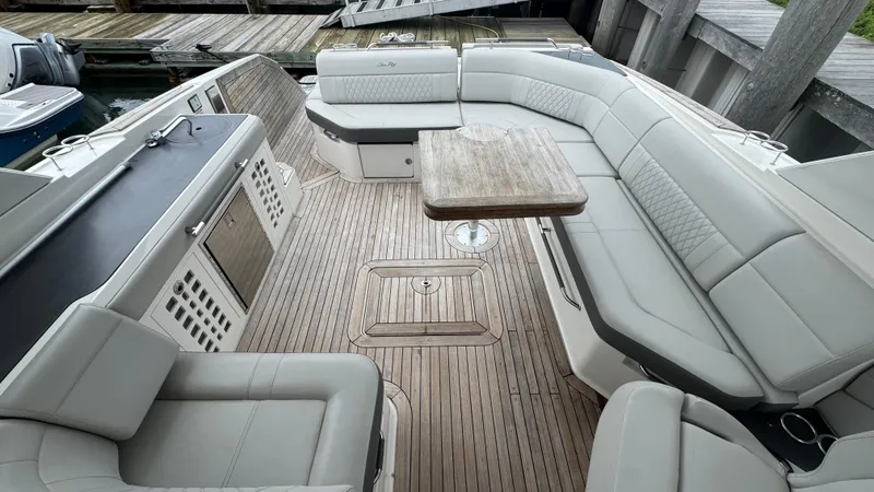 Slide: The Image of 2020 Sea Ray SLX 400 boat interior with spacious seating and wooden table. - 10