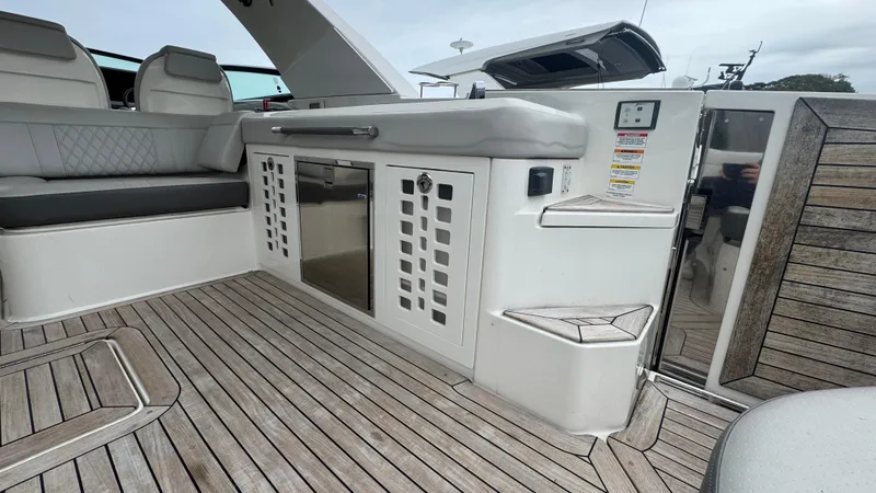 Slide: The Image of 2020 Sea Ray SLX 400 boat interior with sleek seating and wooden flooring. - 8