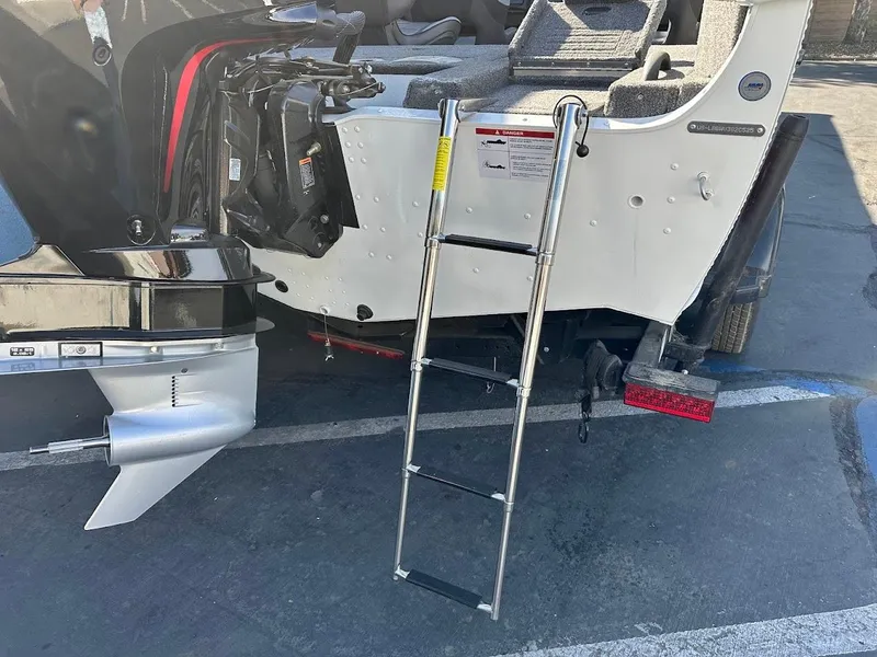 Slide: The Image of 2025 Lund 1875 Crossover XS boat with ladder and outboard motor. - 10