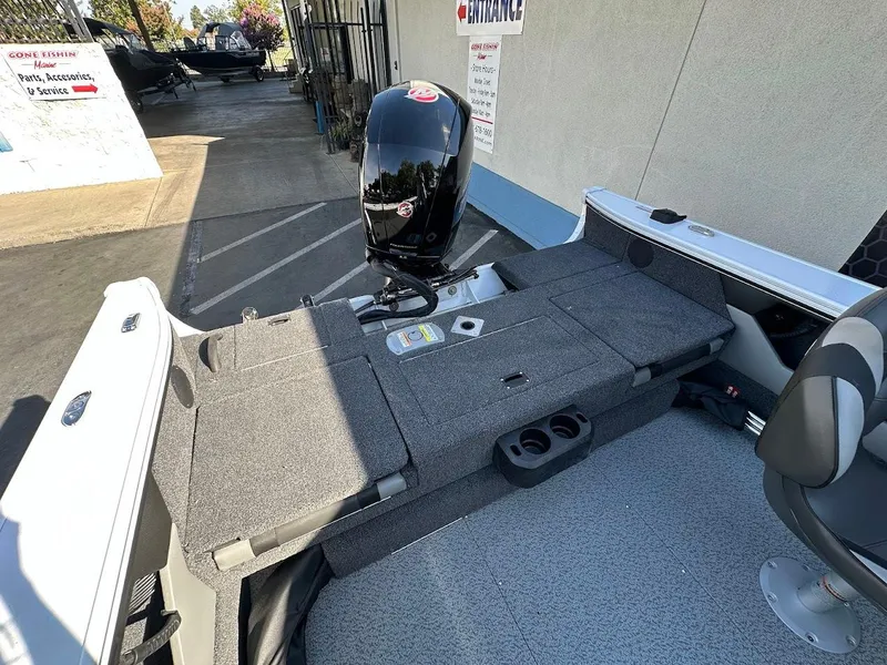 Slide: The Image of 2025 Lund 1875 Crossover XS boat interior with motor and seating area. - 15