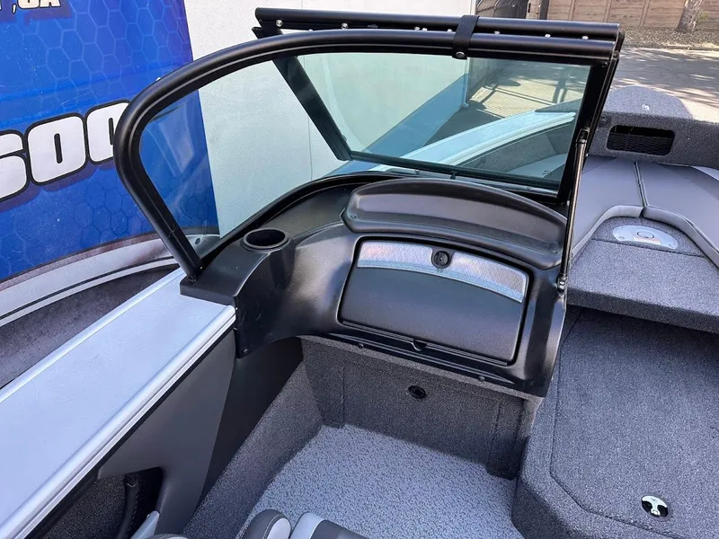 Slide: The Image of 2025 Lund 1875 Crossover XS boat interior with windshield and storage compartment. - 19