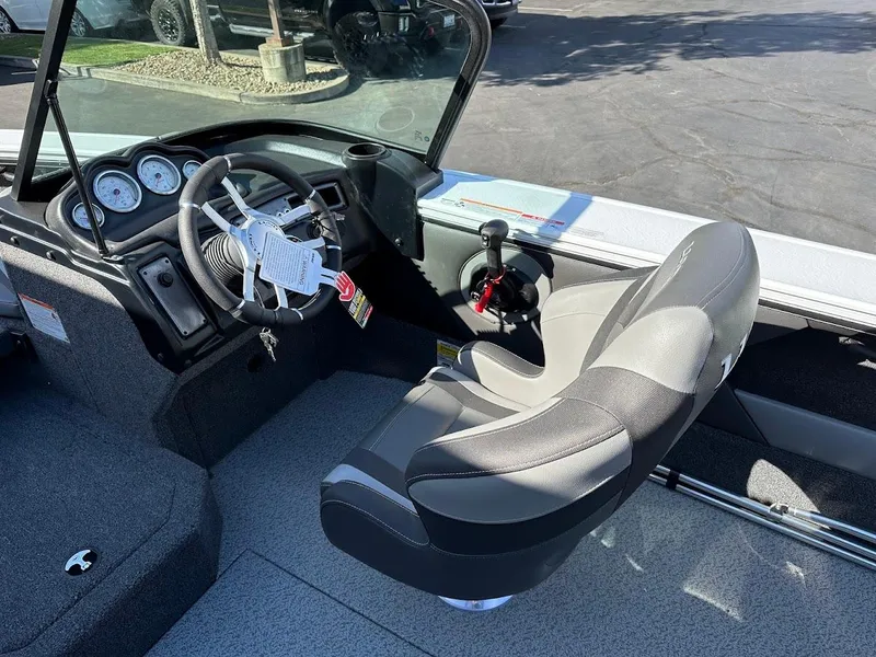 Slide: The Image of 2025 Lund 1875 Crossover XS boat interior with steering wheel and captain's seat. - 20