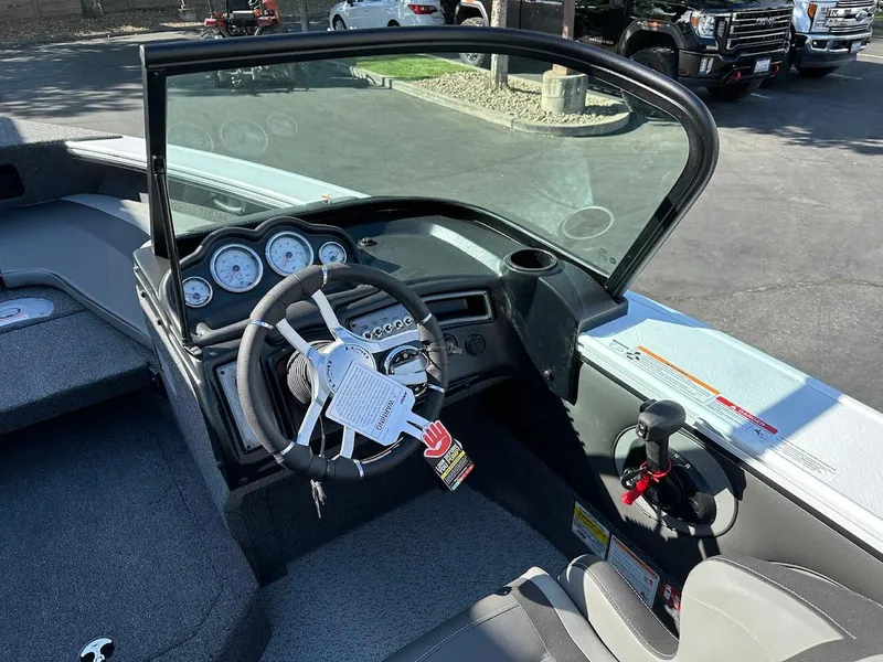 Slide: The Image of 2025 Lund 1875 Crossover XS boat cockpit with steering wheel and dashboard controls. - 21