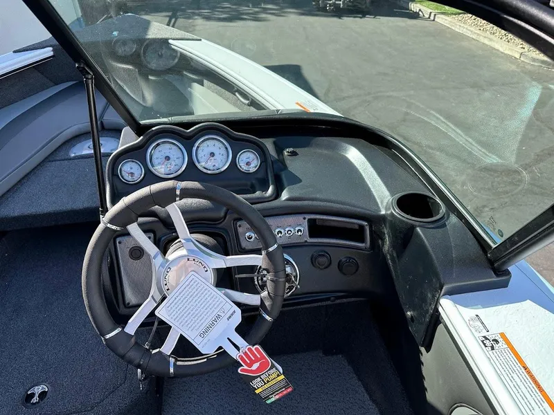 Slide: The Image of 2025 Lund 1875 Crossover XS boat dashboard with steering wheel and gauges. - 22