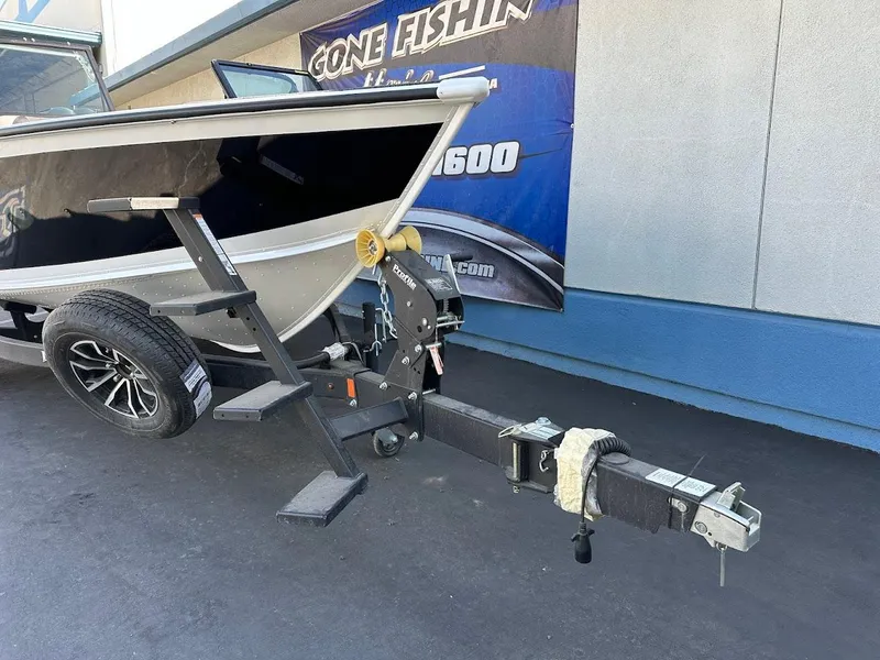 Slide: The Image of 2025 Lund 1875 Crossover XS boat on trailer, parked outside a building. - 4
