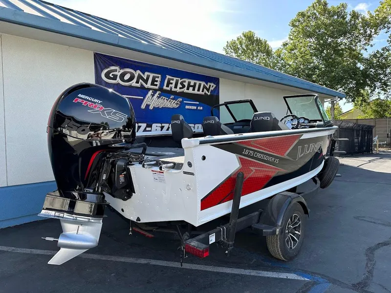 Slide: The Image of 2025 Lund 1875 Crossover XS boat with Mercury Pro XS engine, parked outside dealership. - 7