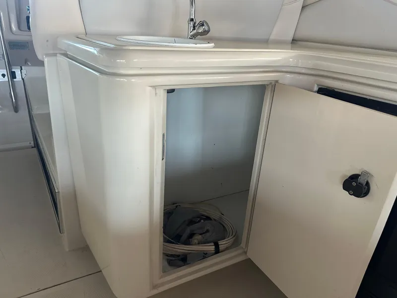 Slide: The Image of Open cabinet on 1997 Regal Commodore 402 boat with sink and storage space. - 14