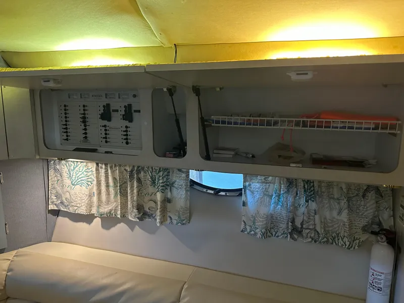 Slide: The Image of Interior of 1997 Regal Commodore 402 with control panel, storage, and floral curtains. - 32
